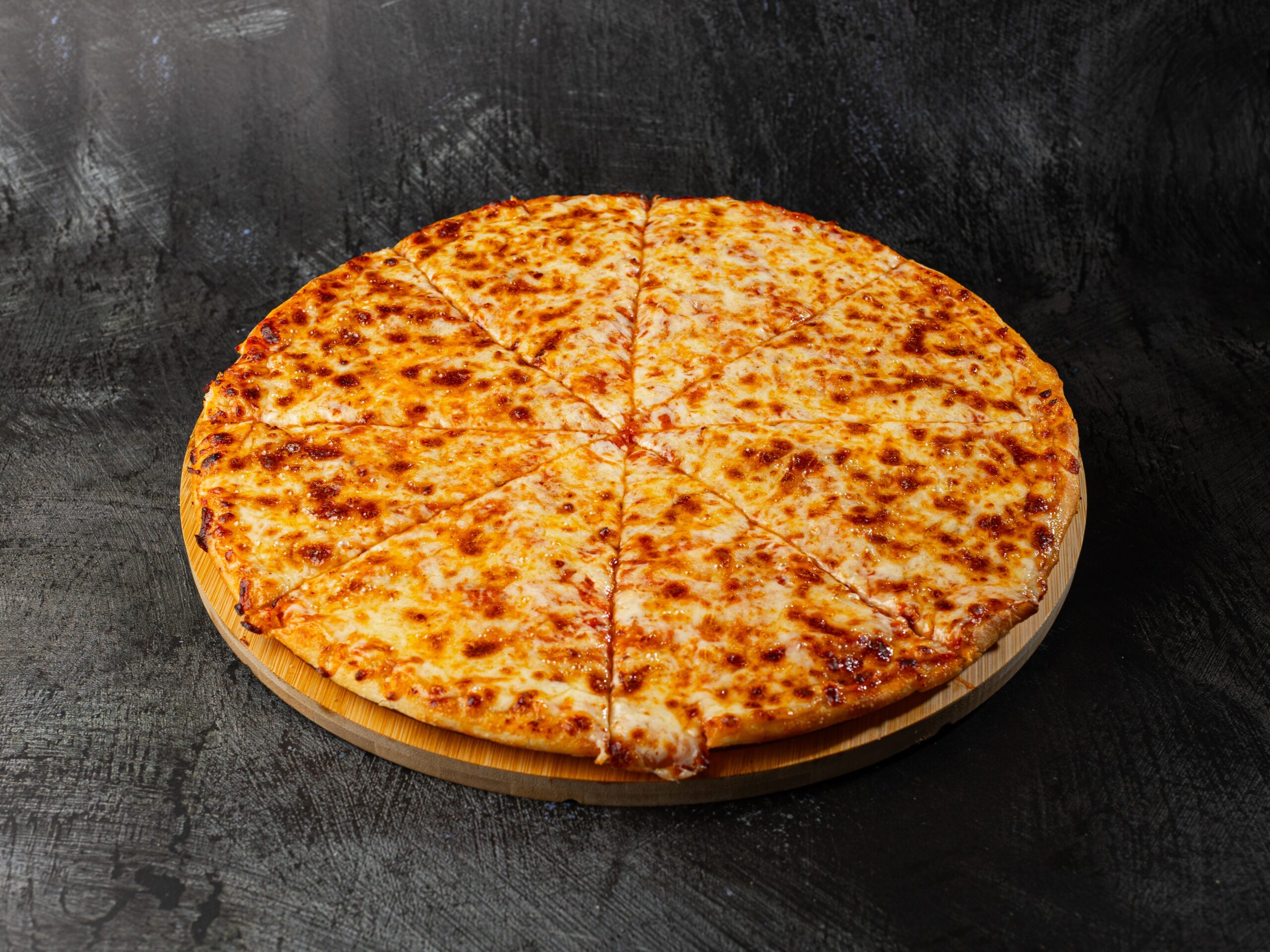 Margherita pizza with melted cheese on wooden board at Bross Slice and Grill
