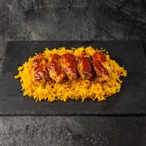 Peri peri chicken wings on saffron yellow rice at Bross Slice and Grill